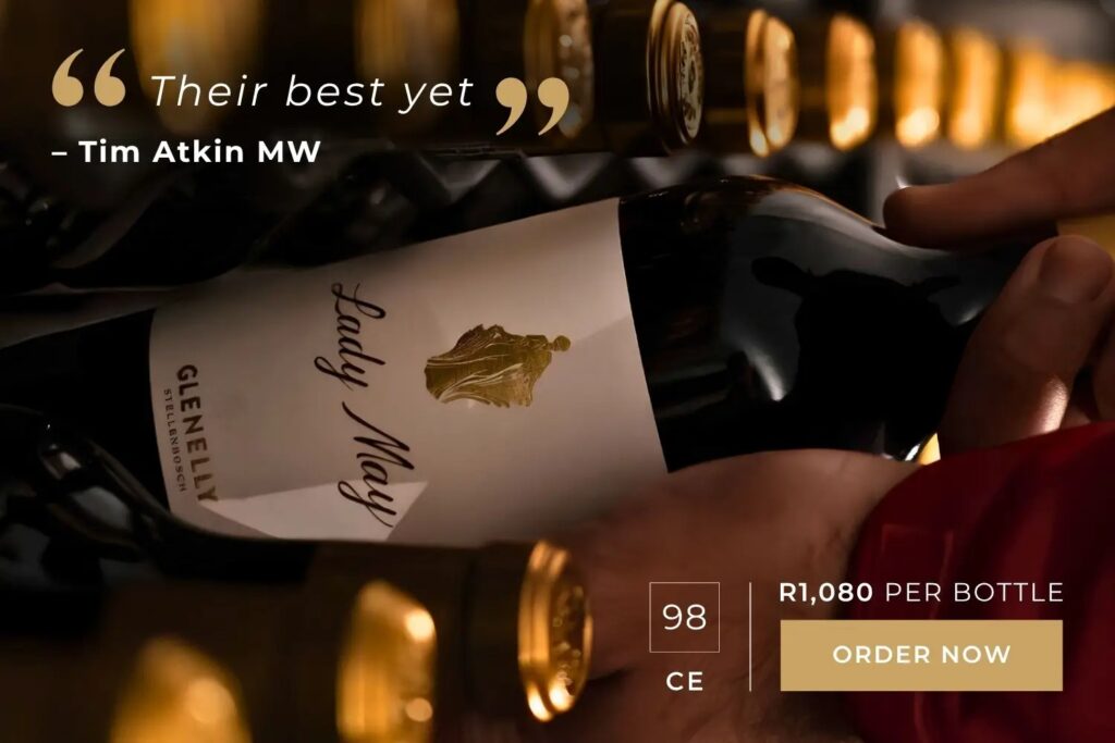 Hand holding a Lady May wine bottle in a cellar with quote "Their best yet" by Tim Atkin MW and price R1,080 per bottle.