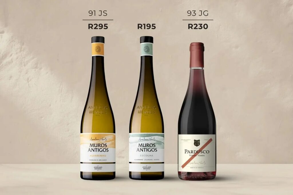 Three wine bottles stand side by side; two white Muros Antigos bottles and one red Pardusco bottle, each labeled with ratings and prices in South African Rand.